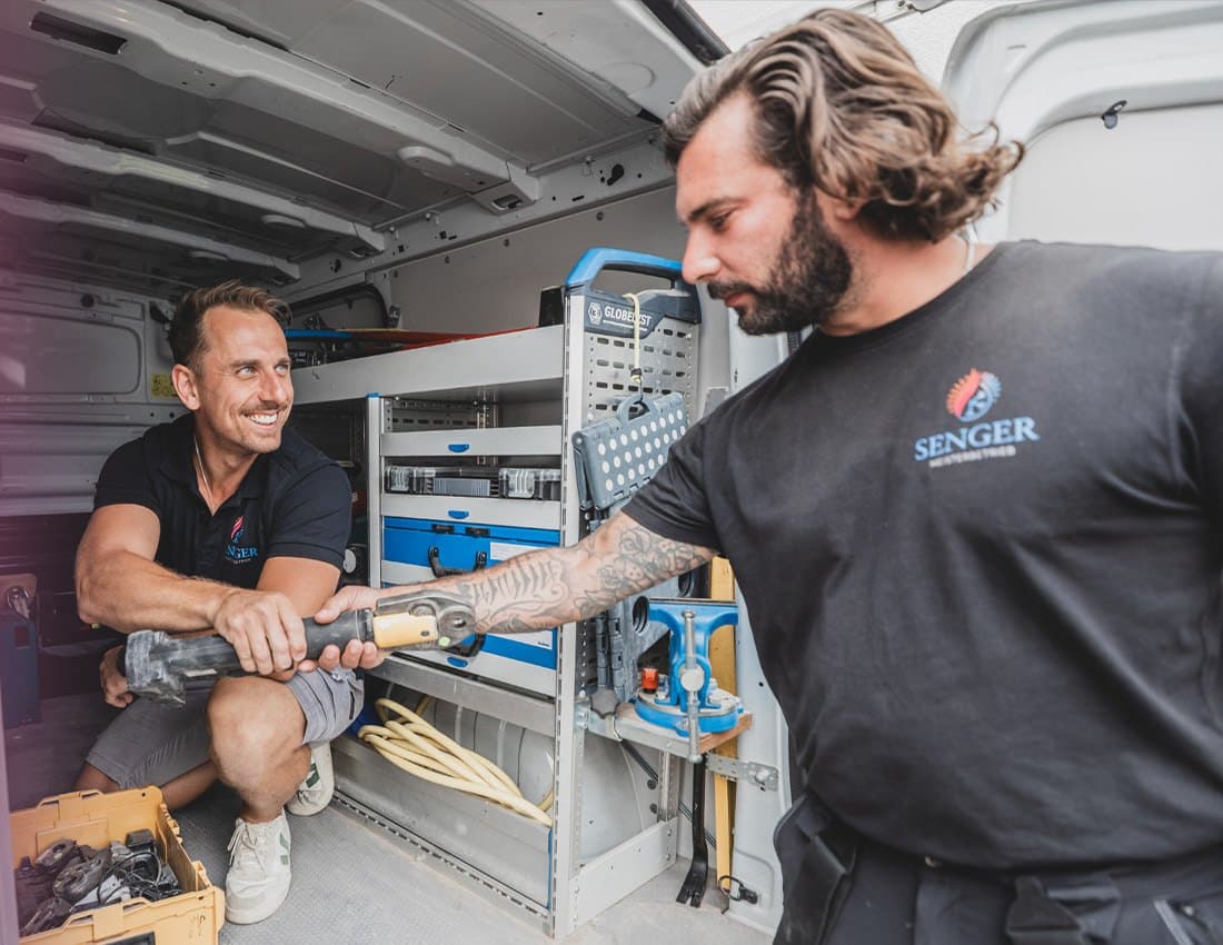 Zwei Monteure von Senger Haustechnik am Firmentransporter mit Werkzeug